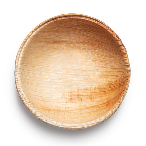 A round, shallow palm leaf bowl with a smooth texture and a natural gradient of light brown to dark brown, beautifully displaying the grains of the material. The bowl is empty with a slightly glossy finish, making it an ideal piece for eco-friendly mini disposable sauce bowls in sustainable tableware collections. This product is named Round Palm Leaf Eco-Friendly Mini Disposable Sauce Bowls (2.5 oz.).