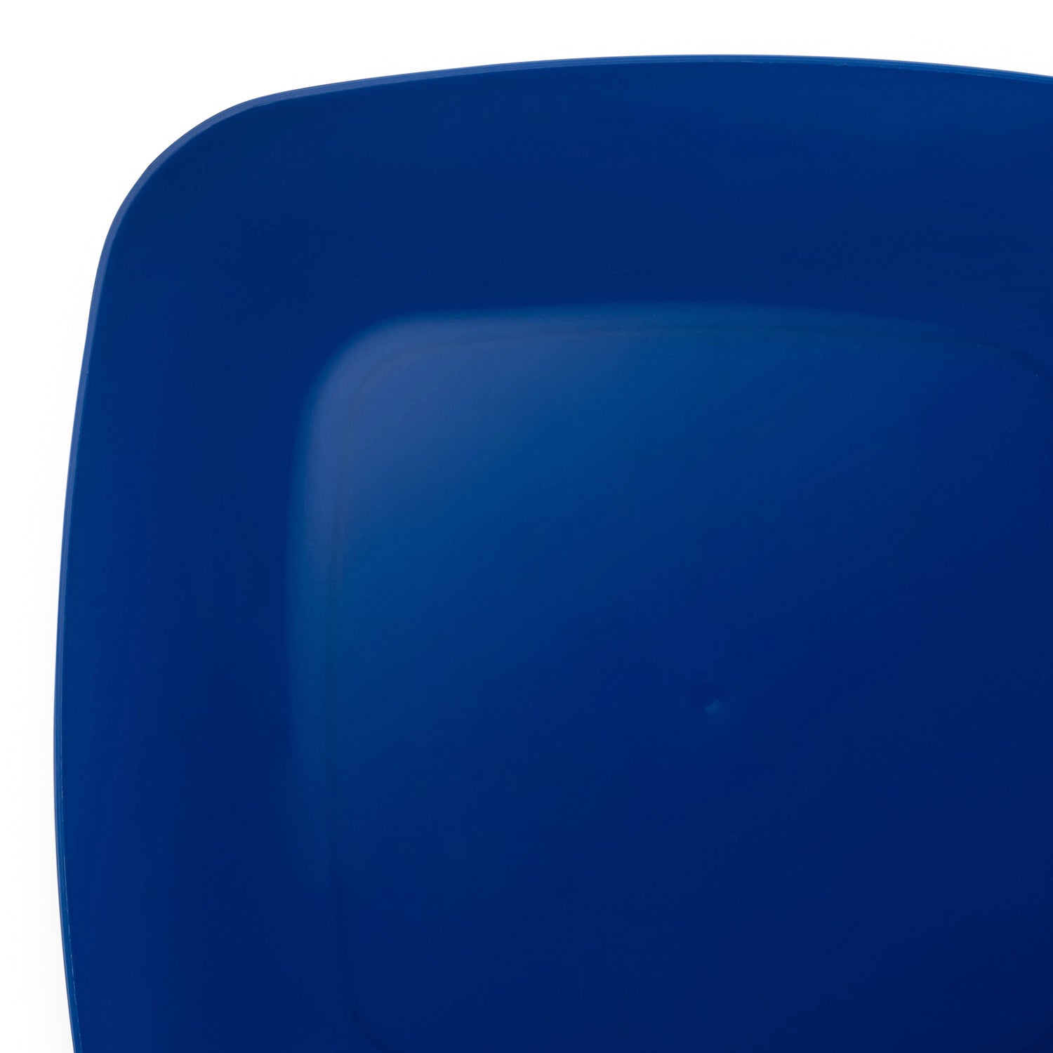 A close-up image of the corner of a dark blue, rounded square Blue Flat Rounded Square Plastic Salad Plate (7.25") with curved edges. The image highlights the smooth, glossy surface and rich blue color, emphasizing the gentle curve of the edge.